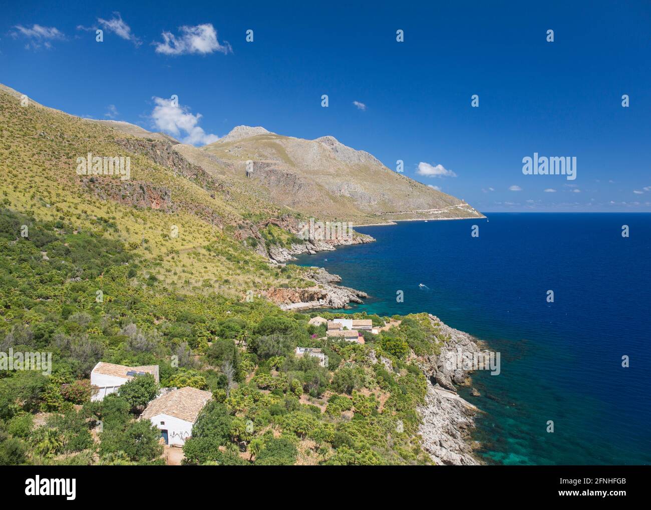 Réserve naturelle de Zingaro, Trapani, Sicile, Italie. Vue sur la côte du golfe de Castellammare de Punta Leone, maisons rurales accrochant à flanc de colline. Banque D'Images