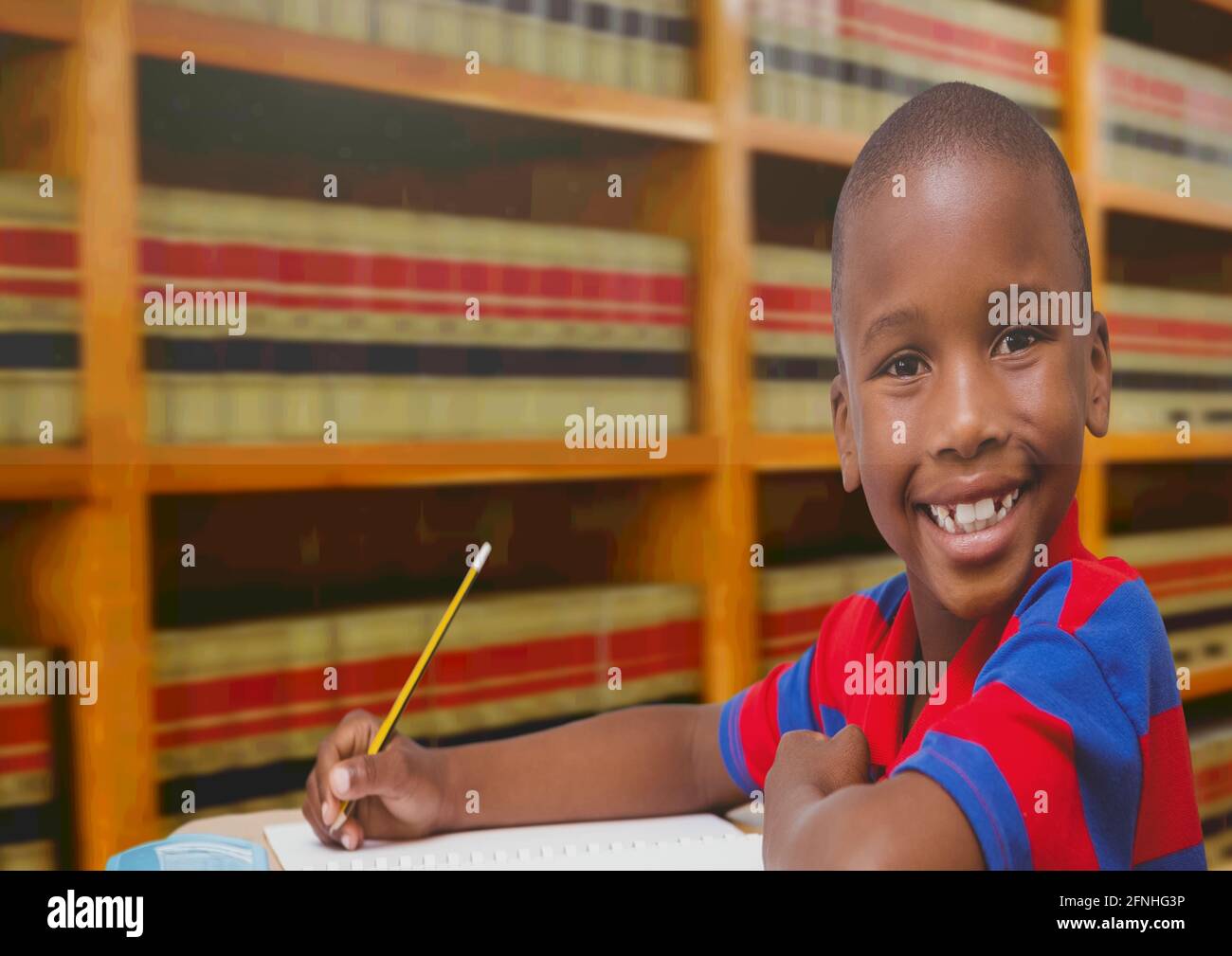Composition du portrait d'un écolier afro-américain souriant dans la bibliothèque Banque D'Images