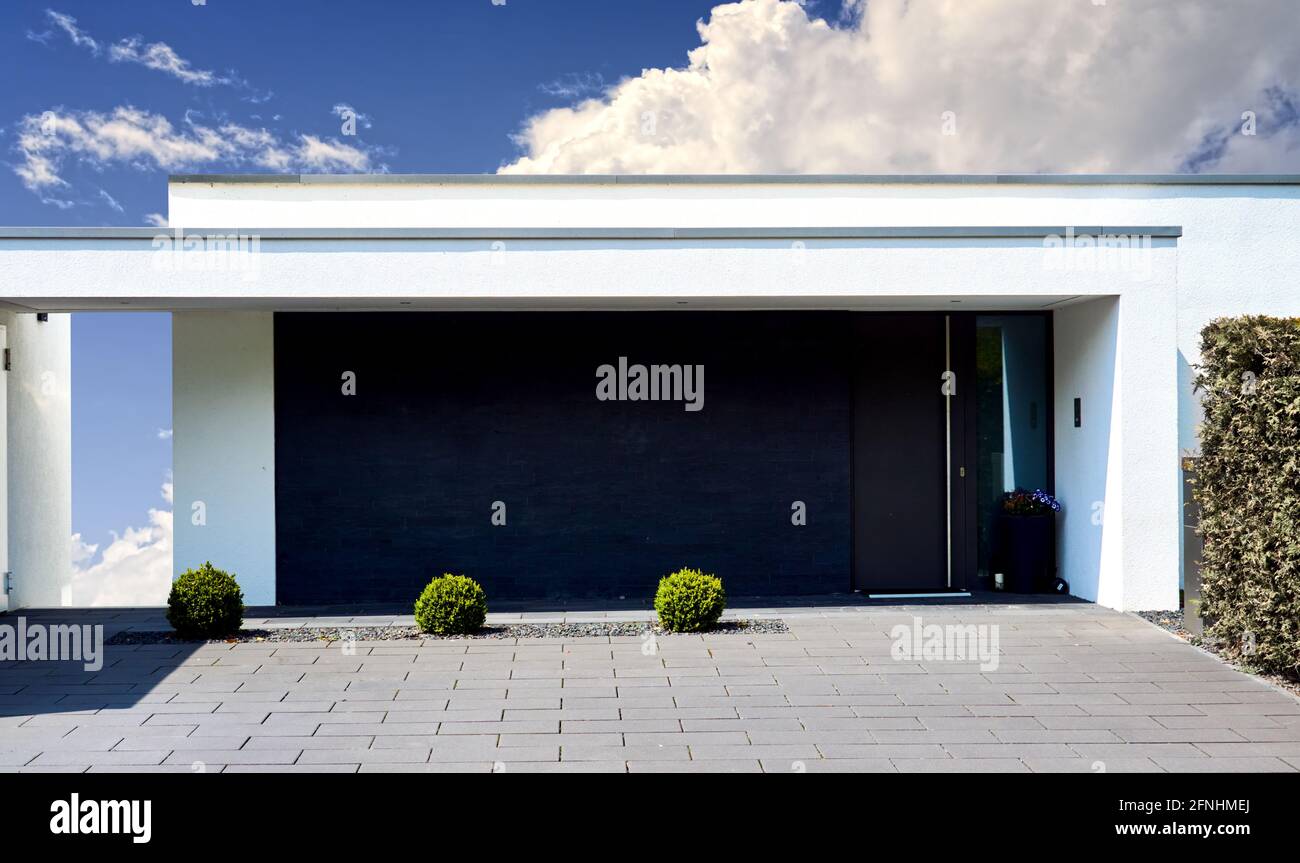 Architecture abstraite minimaliste à l'avant d'une maison unifamiliale moderne exclusive avec un jardin austère avec gravier et pavés, en pupublii Banque D'Images