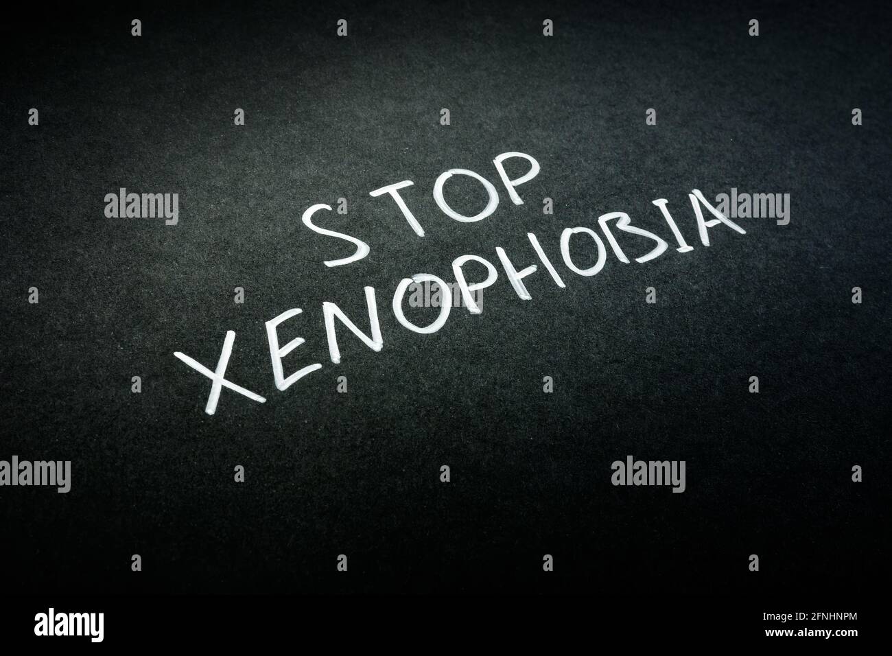 Stop xénophobie signe manuscrit sur papier noir. Banque D'Images