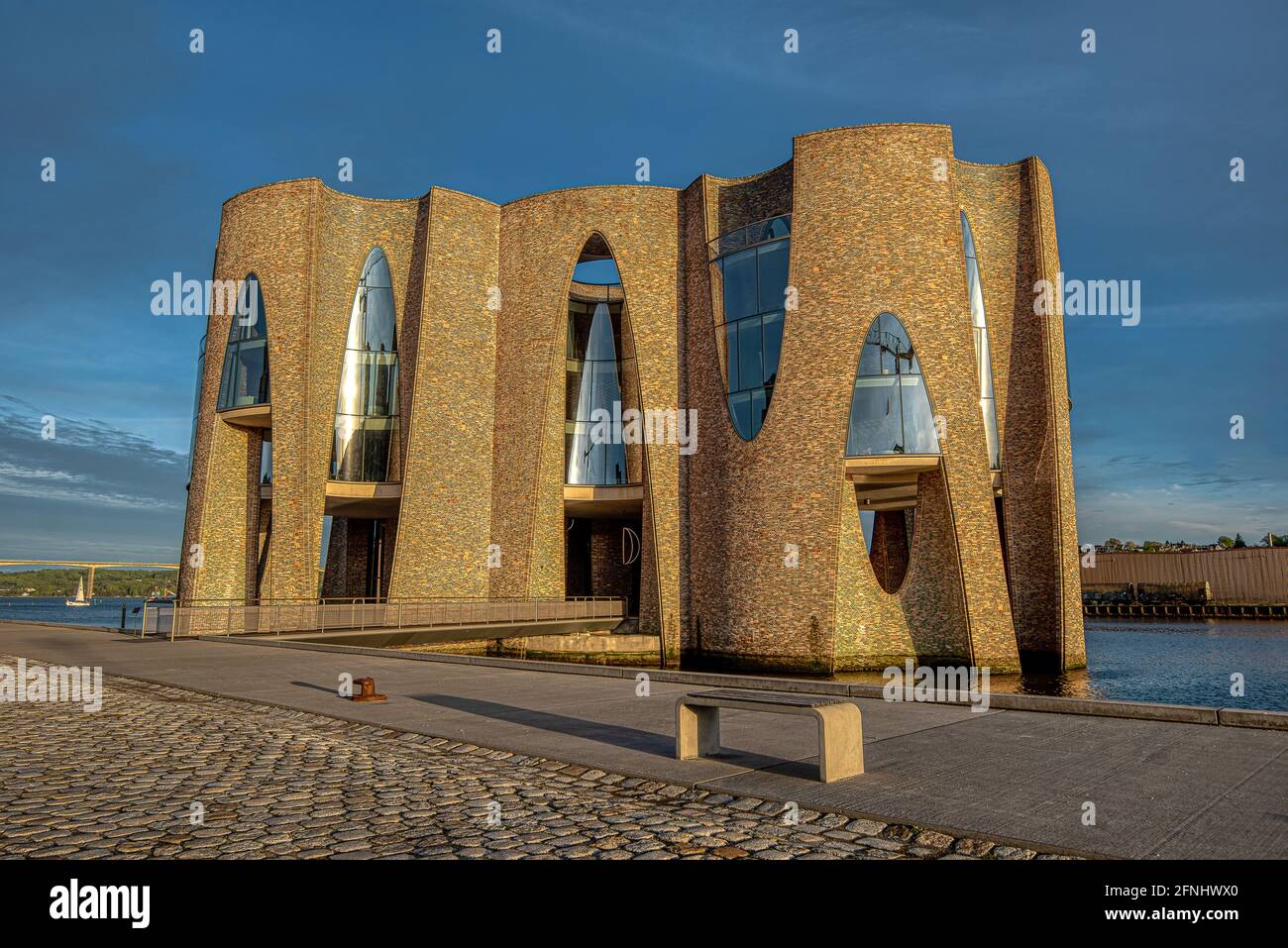 Banc avec de longues ombres en fin d'après-midi devant le bâtiment emblématique de Flordenhus Vejle, Danemark, 10 mai 2021 Banque D'Images