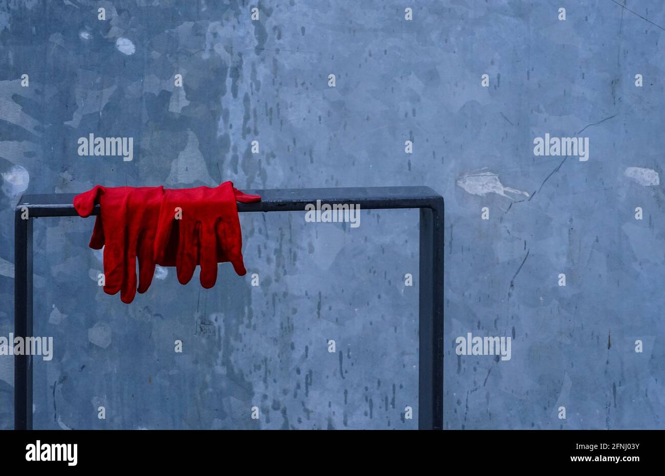 Une paire de gants rouges perdus sur un support de vélo. Banque D'Images