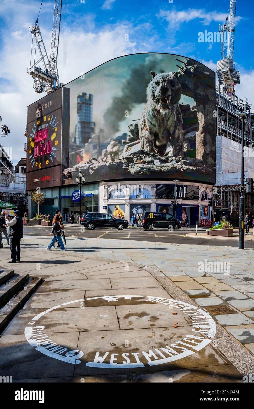Londres, Royaume-Uni. 17 mai 2021. Le jour où les cinémas sont autorisés à rouvrir, un panneau d'affichage 3-D en direct, Piccadilly Lights, lance l'ARMÉE DU FILM à succès À venir de Zack Snyder (Justice League). En utilisant l'intégralité de l'écran numérique incurvé de Piccadilly Circus, l'activation introduit les Londoniens à "Valentine", le tigre zombie qui apparaît dans le film. Le tigre du VFX, créé par le superviseur des effets visuels Marcus Taormina (Bird Box, Guardians of the Galaxy) en itinérance autour de Las Vegas post-apocalyptique. Crédit : Guy Bell/Alay Live News Banque D'Images