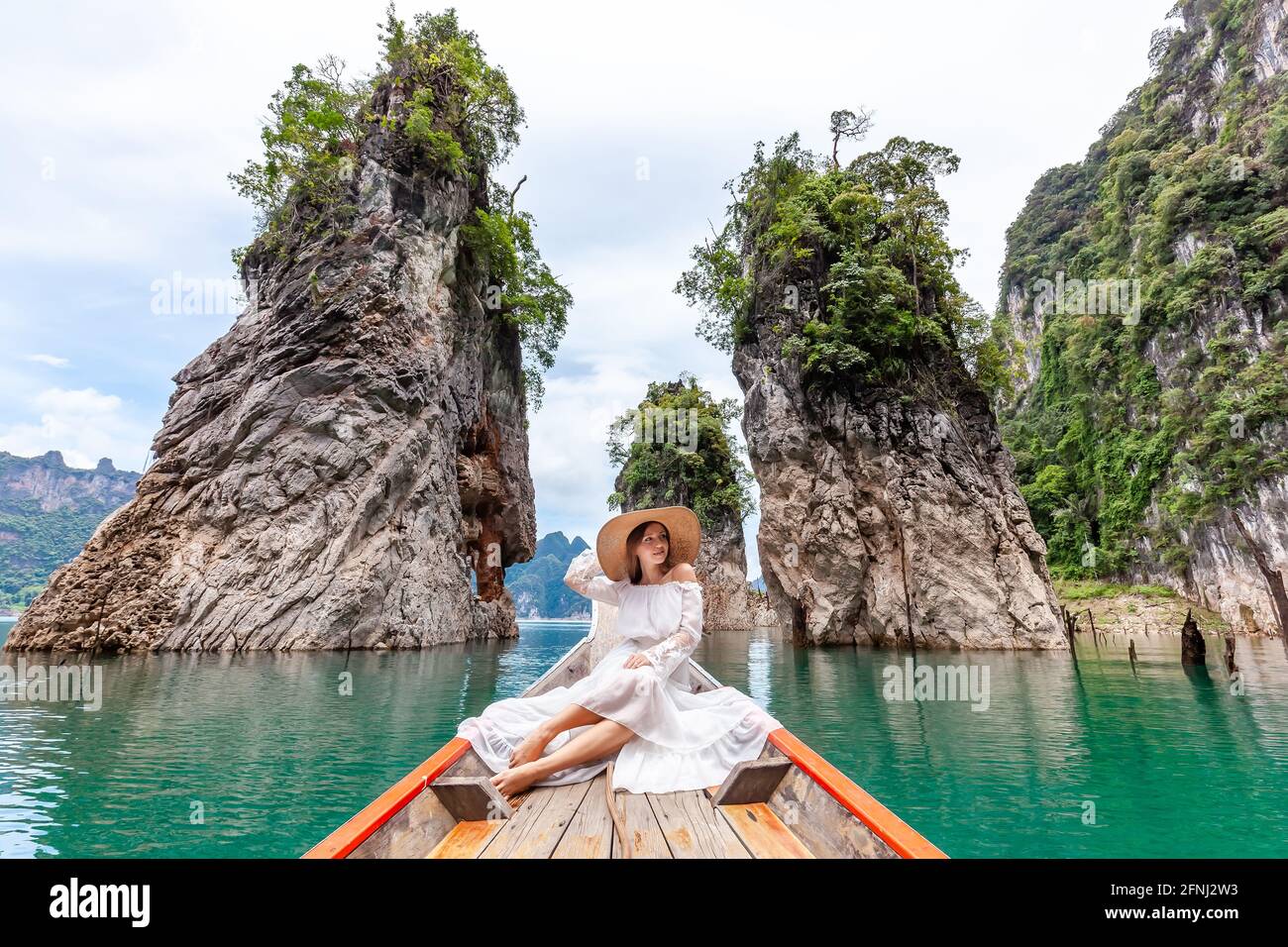 Voyageuse assise sur un bateau près des célèbres trois rochers du parc Khao Sok, Thaïlande Banque D'Images