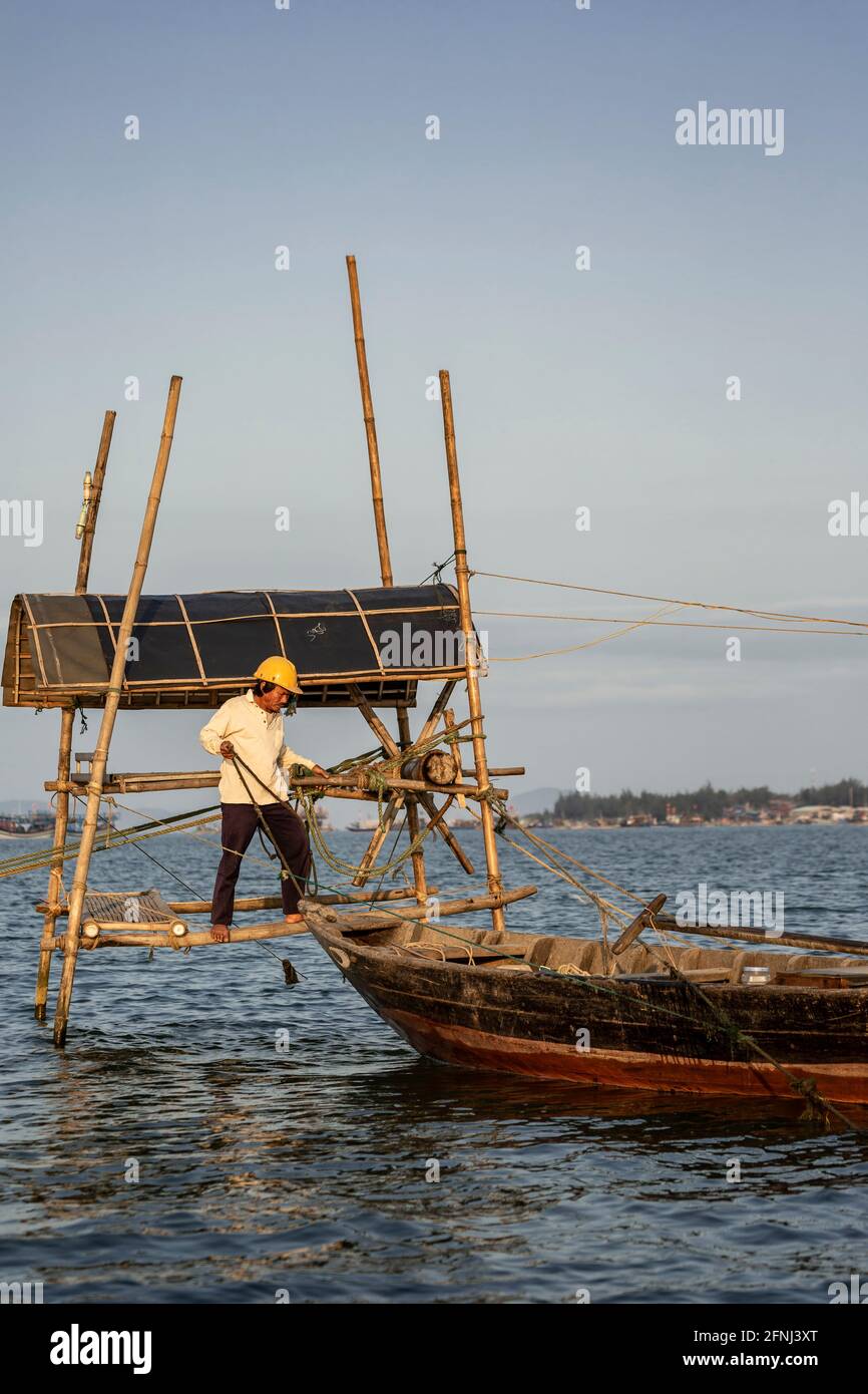 Pêcheur, bateau de pêche et système de poulie de filet de pêche, Thu bon River, Hoi an, Vietnam Banque D'Images