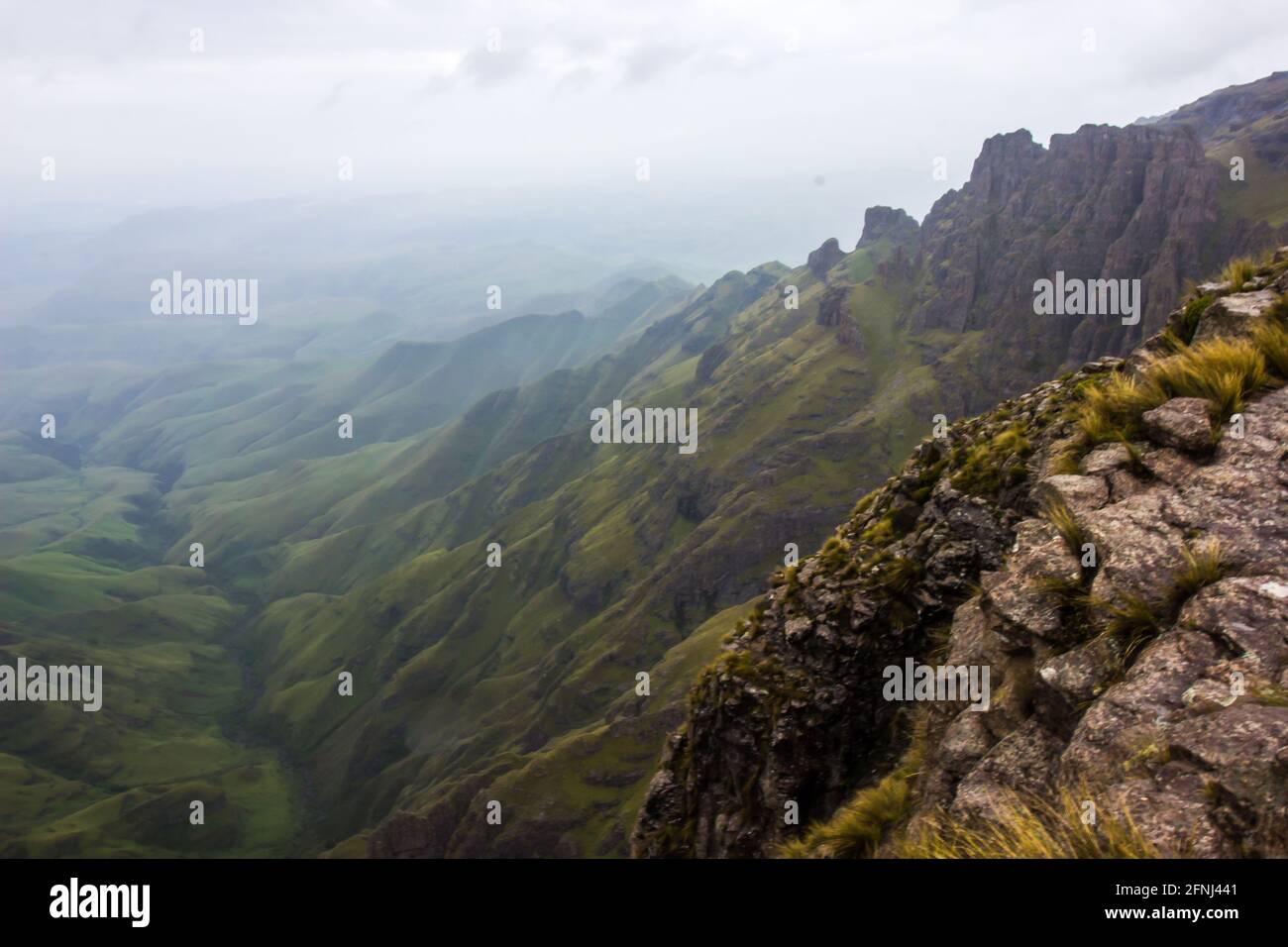 Vue depuis les hauts sommets des montagnes du Drakensberg à la frontière entre l'Afrique du Sud et le Lesotho, avec les collines verdoyantes et les montagnes en contrebas Banque D'Images