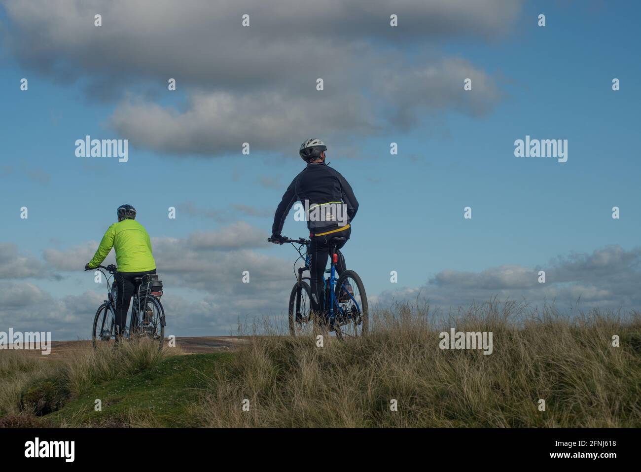 Deux cyclistes passent devant vous et s'arrêtes pour observer la campagne environnante dans les Durham Dales Banque D'Images