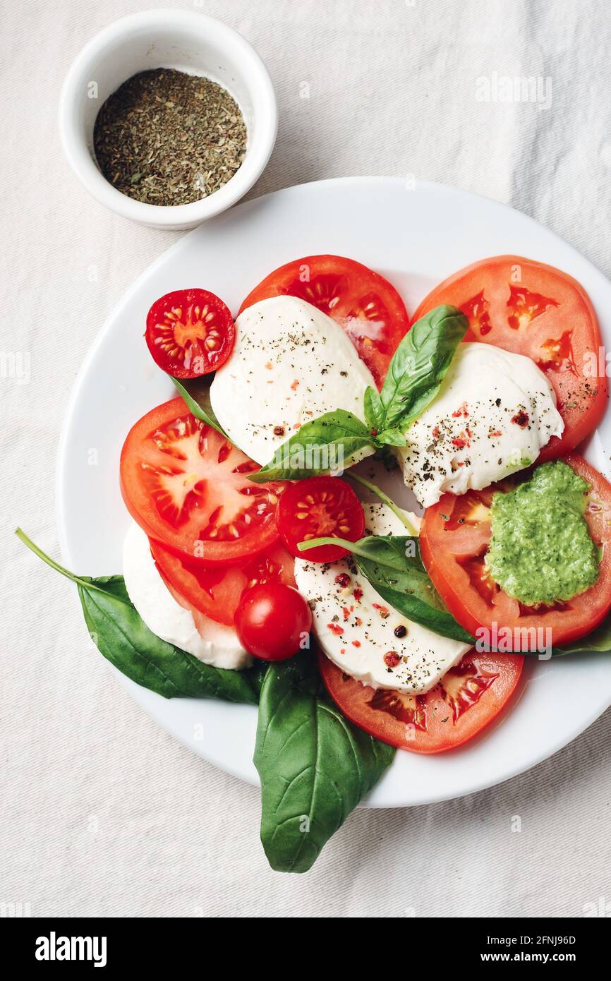 Salade Caprese. Tomates, fromage mozzarella, feuilles de basilic et sauce pesto. Banque D'Images