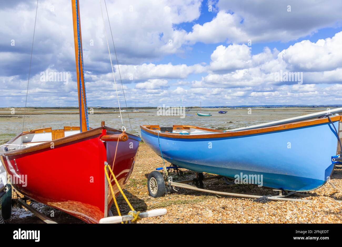 Des dinghies de voile amarrées sur le bord de mer à Snowhill Creek sur Chichester Harbour avec East Head au loin, West Wittering, West Sussex, Angleterre, Royaume-Uni Banque D'Images