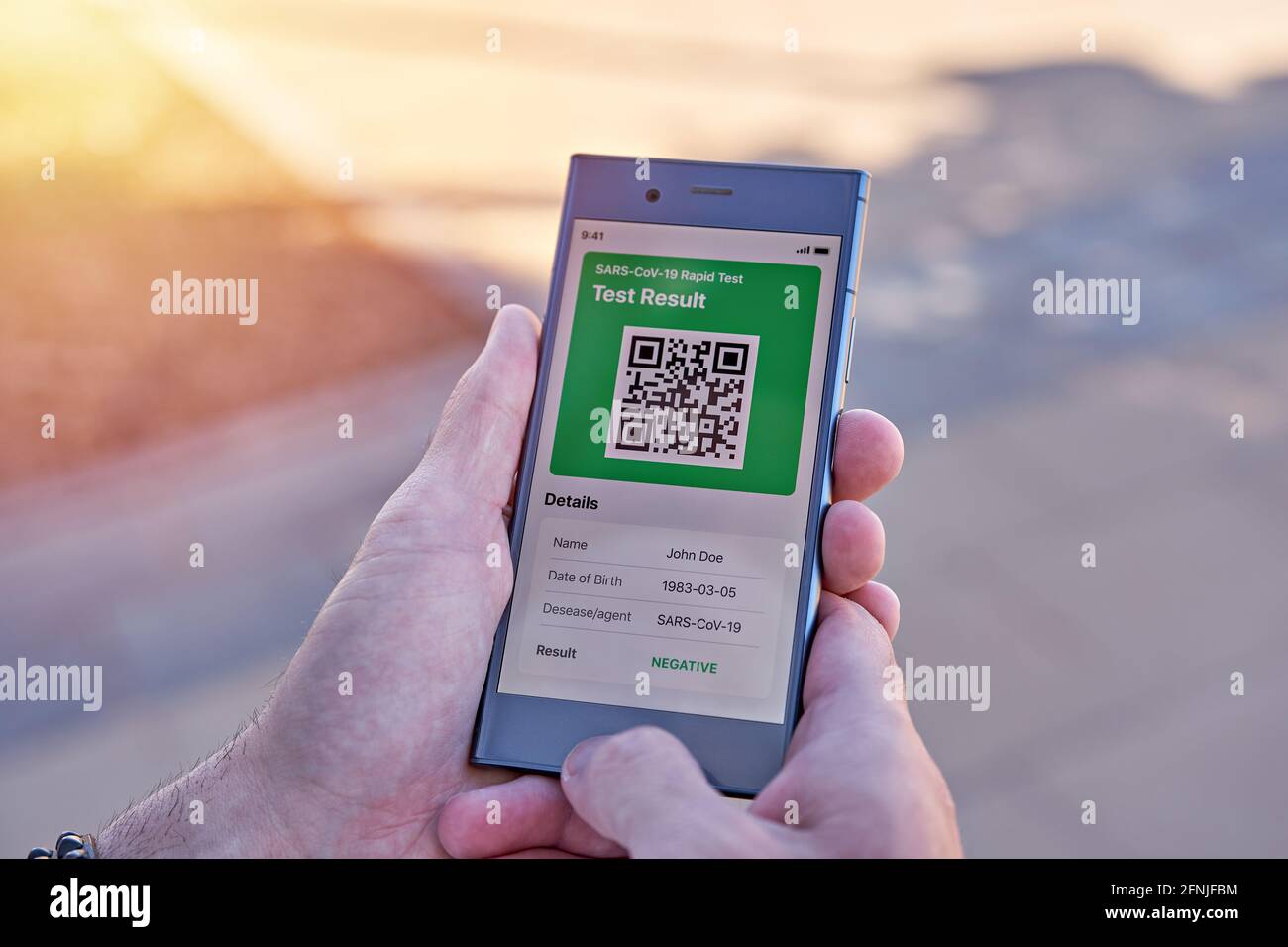 Homme tenant smartphone affichant sur l'application mobile négatifs COVID-19 résultats de test express. Passeport vaccinal d'immunité, certificat de vaccination Banque D'Images
