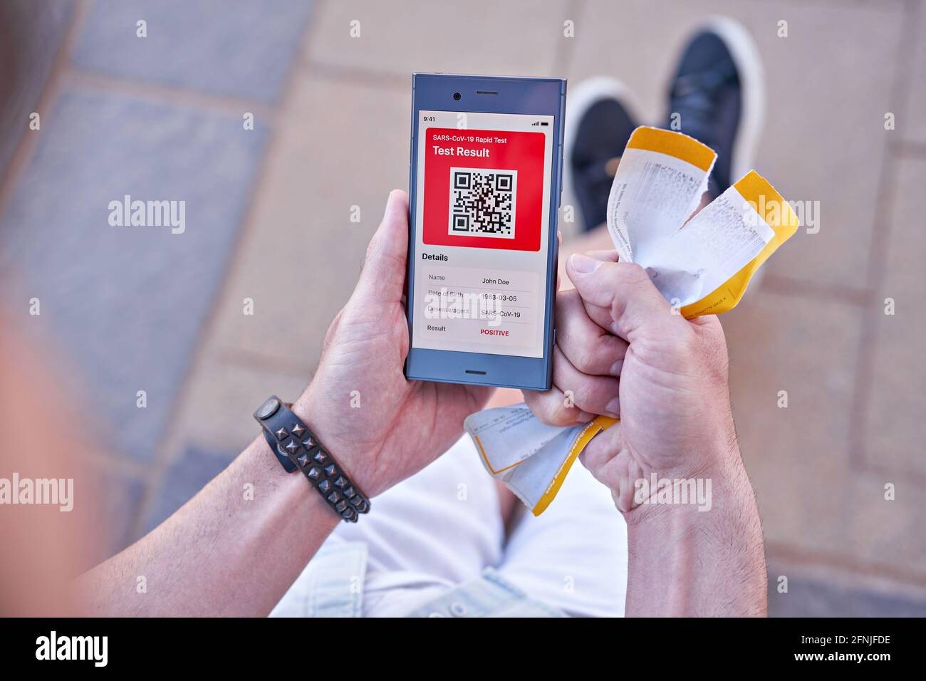 La personne a reçu un message sur APP mobile au sujet du résultat positif du test COVID-19, carte d'embarquement déchirée en main. Échec des plans de vacances, annulation du concept de vol Banque D'Images