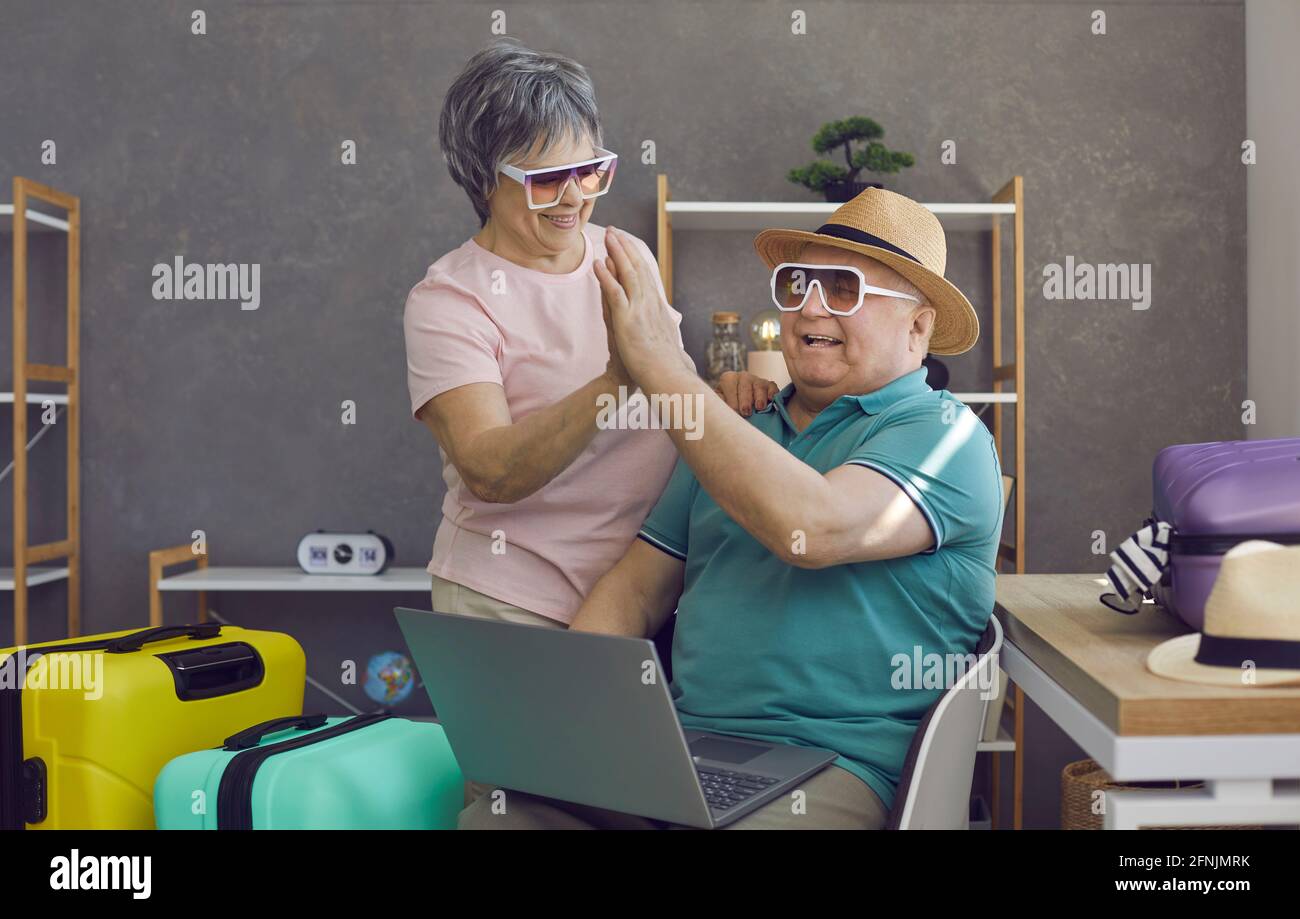 Un couple de personnes âgées heureux qui planifie des vacances et qui  utilise un ordinateur portable pour réserver chambre d'hôtel parfaite en  ligne Photo Stock - Alamy