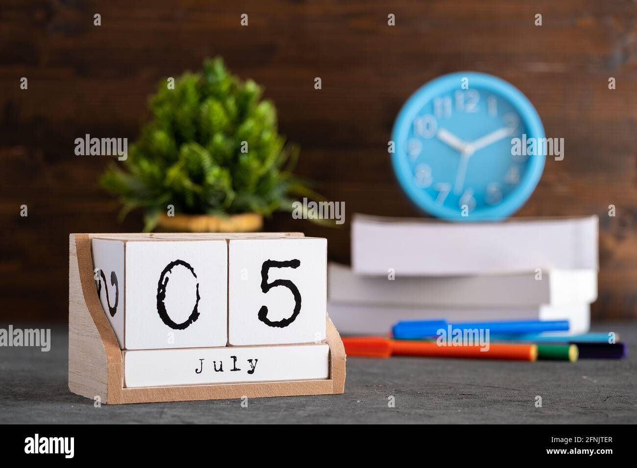 Le 05 juillet. Juillet 05 calendrier cube en bois avec des objets flous sur fond. Banque D'Images