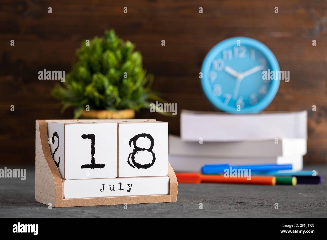18 juillet. Juillet 18 calendrier cube en bois avec des objets flous sur fond. Banque D'Images