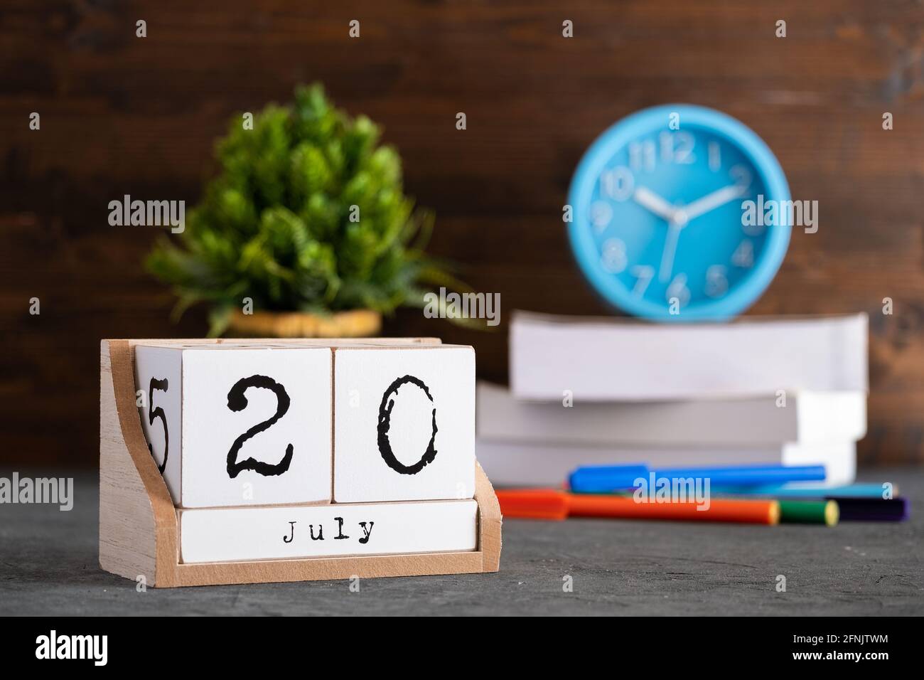 20 juillet. Juillet 20 calendrier cube en bois avec des objets flous sur fond. Banque D'Images