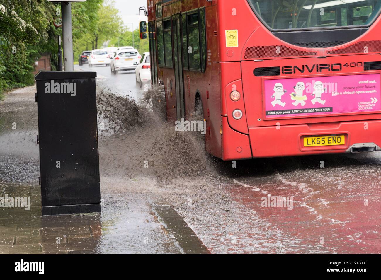 Le bus rouge de londres fait Splash de l'inondation éclair sur la route circulaire sud, Grand Londres, Angleterre Banque D'Images