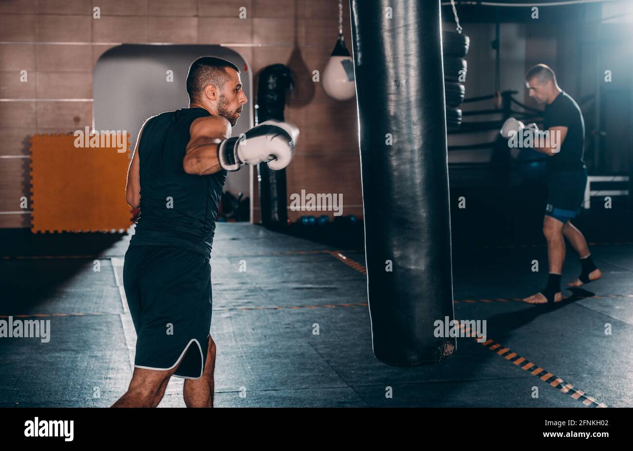 Homme sportif avec un sac de boxe gants de boxe à la salle de sport.  Concept a propos de sport, fitness, arts martiaux Photo Stock - Alamy