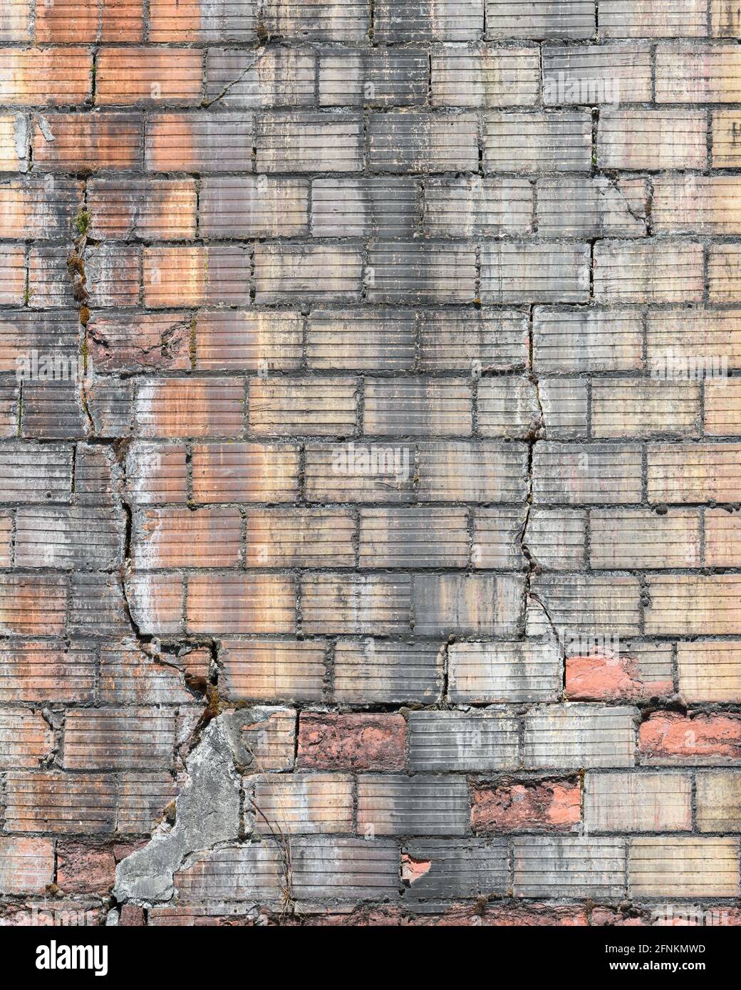 Briques inhabituelles avec un motif rainuré dans un vieux mur qui est fissurée et sale et qui a besoin d'être réparée pour éviter l'effondrement Banque D'Images