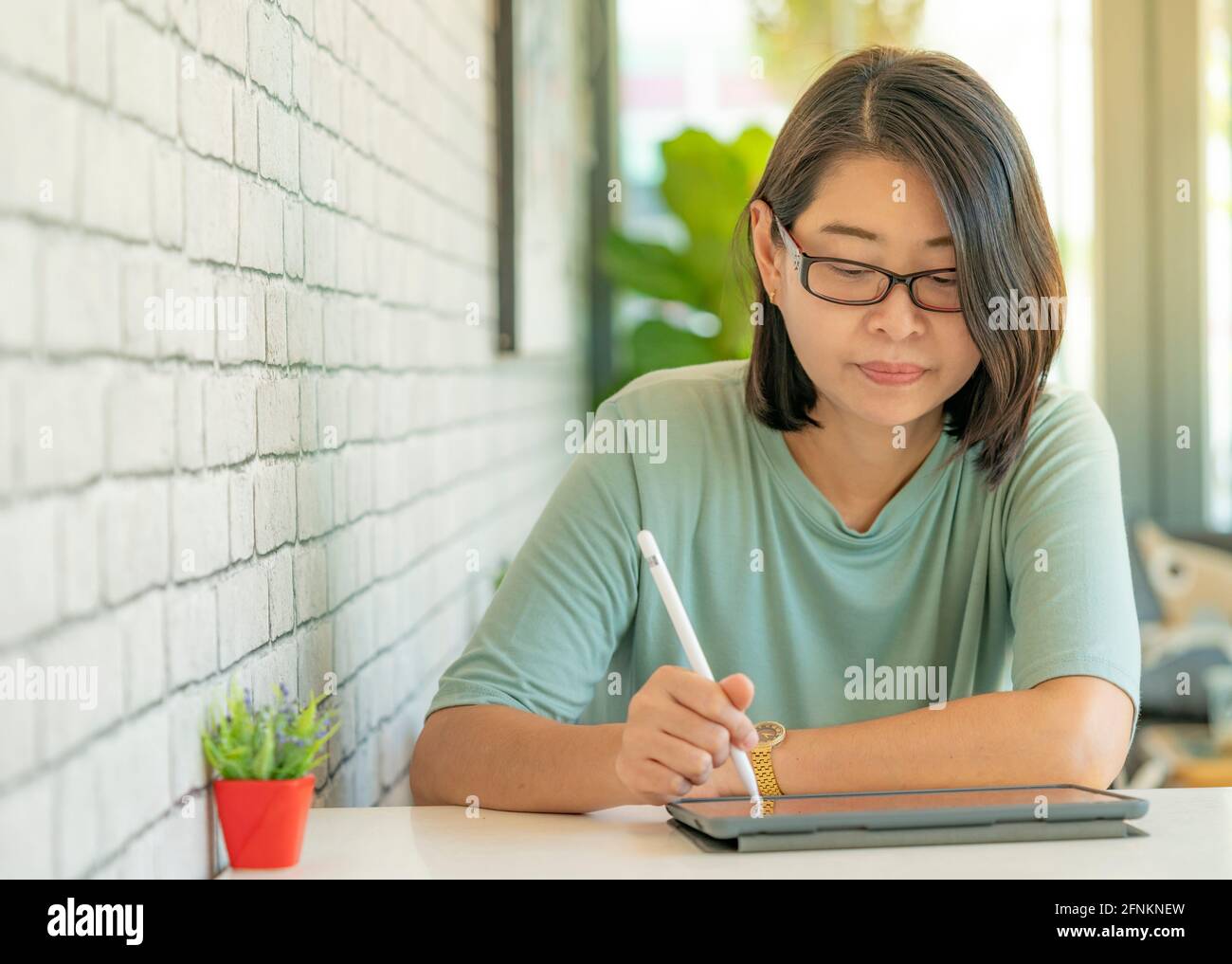 Portrait asiatique femme travaillant avec une tablette dans un café. Banque D'Images