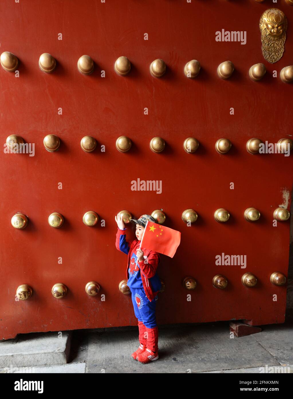 Un garçon chinois tenant le drapeau chinois près de la porte du Temple du ciel à Beijing, en Chine. Banque D'Images