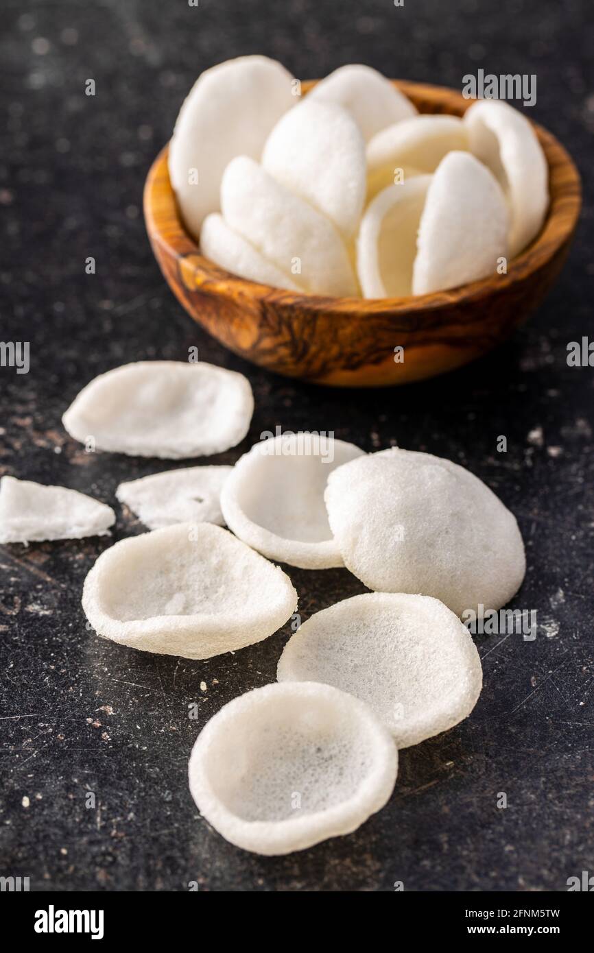 Croustilles en-cas blanches soufflées. Croustilles blanches sur table noire. Banque D'Images