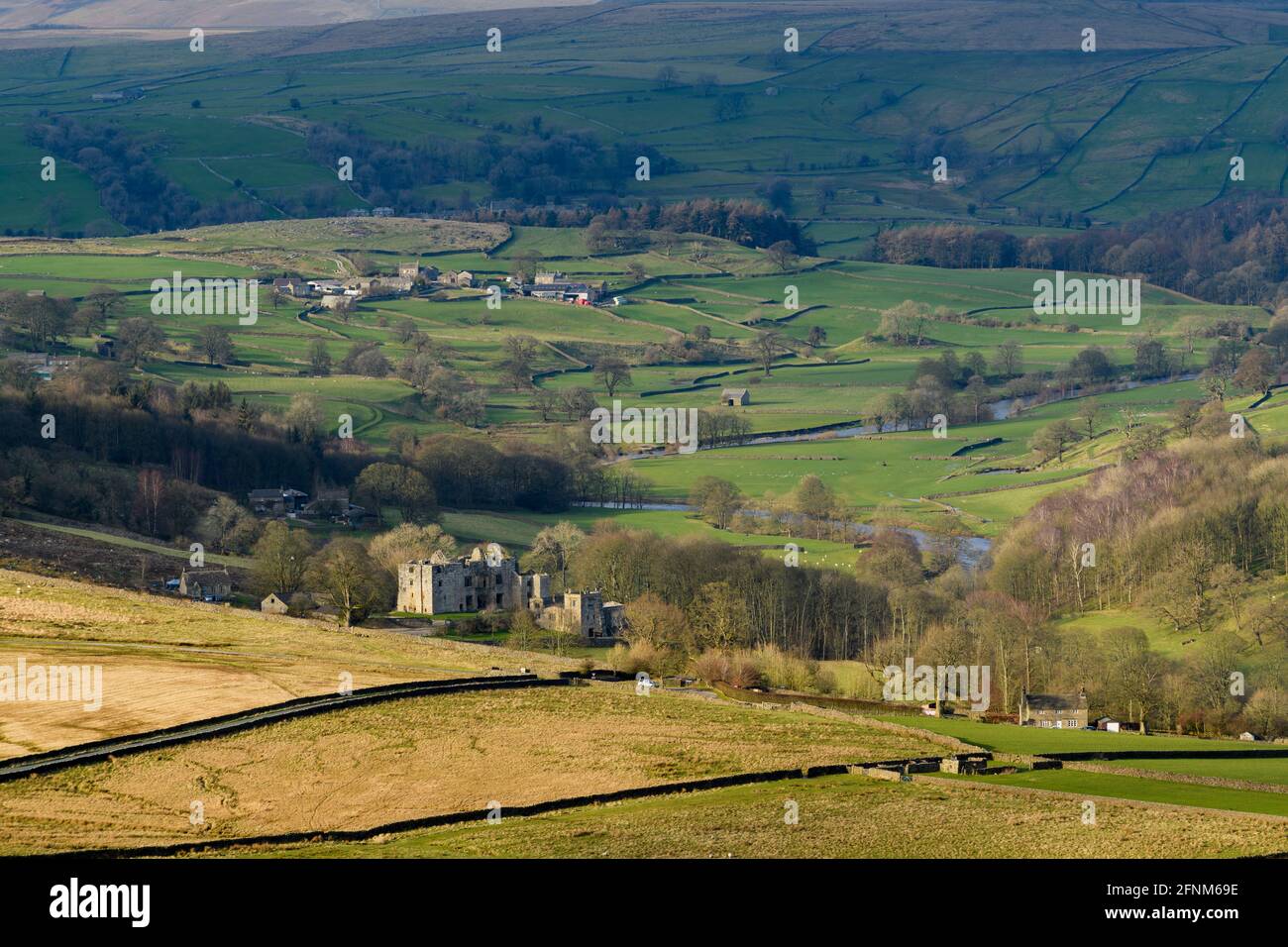 Vue panoramique sur la campagne de Wharfedale (large vallée verdoyante, collines ondoyantes, hautes collines et ruines de la tour de jardin illuminée) - Yorkshire Dales, Angleterre, Royaume-Uni. Banque D'Images