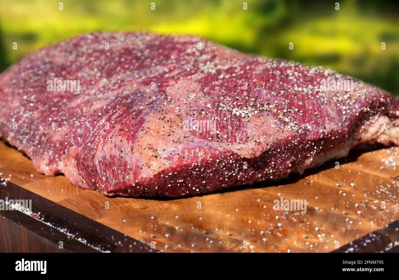 Grande portion de poitrine de bœuf tendre et tendre brut pour rôtir prêt à cuire sur une planche à découper en bois en gros plan Banque D'Images