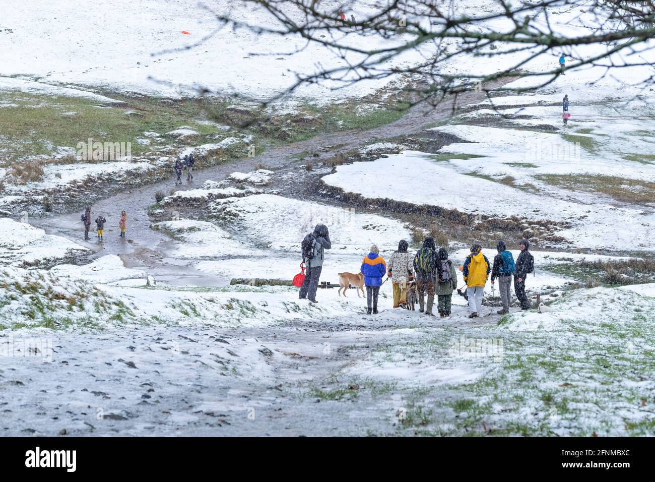 Les gens qui profitent d'une promenade dans la neige sur Rough Tor sur Bodmin Moor dans les Cornouailles. Banque D'Images