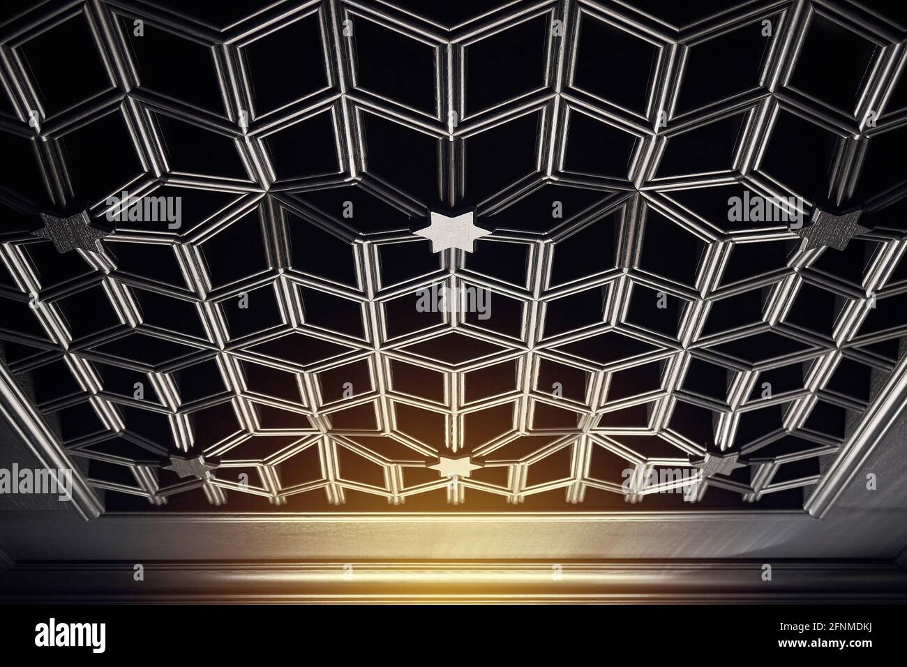Élégant plafond en bois antique noir sur plusieurs niveaux de style gothique avec des motifs géométriques dans une pièce spacieuse semi-sombre Banque D'Images