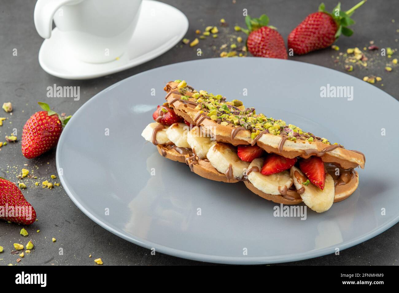 gaufres à croque-monsieur avec banane, fraise et chocolat et pistache sur le dessus Banque D'Images