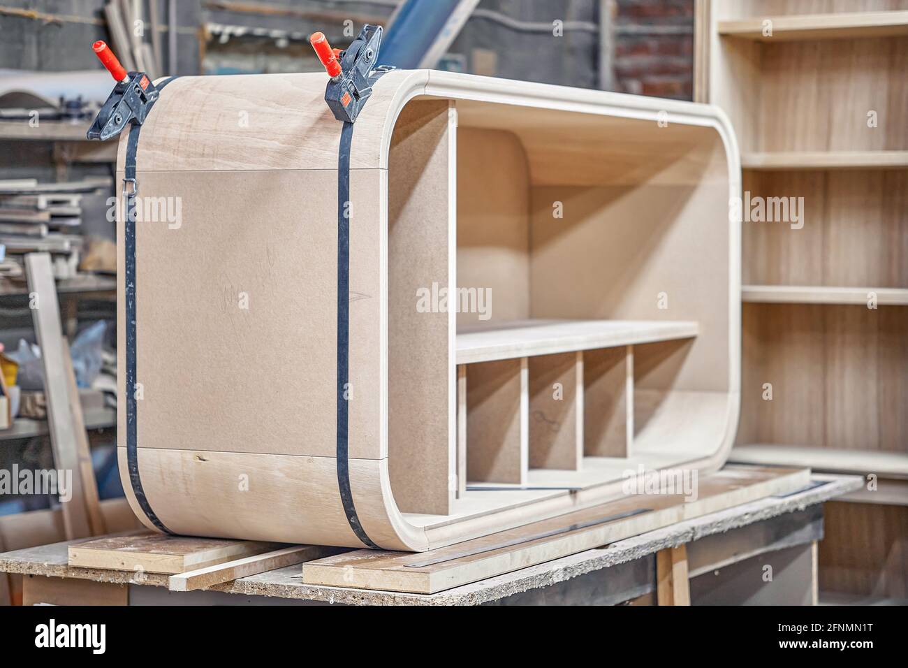 Fabrication de boîtier incurvé de nouvelle armoire en bois avec des  étagères à l'aide de attache à bande contemporaine sur banc de travail dans  atelier de menuiserie Photo Stock - Alamy