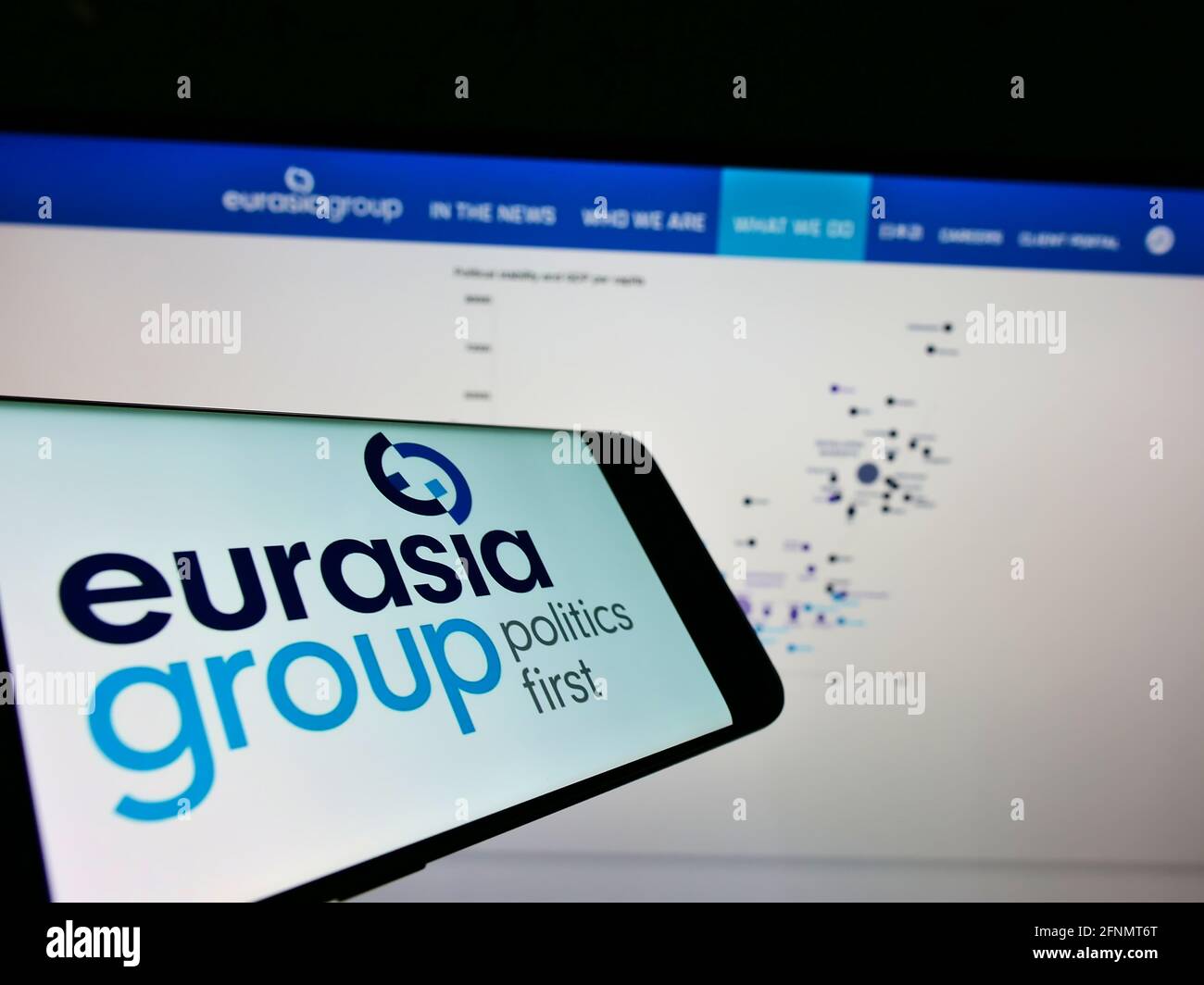 Téléphone portable avec logo de la société américaine de conseil Eurasia Group Ltd sur écran devant le site Web. Effectuez la mise au point au centre-droit de l'écran du téléphone. Banque D'Images