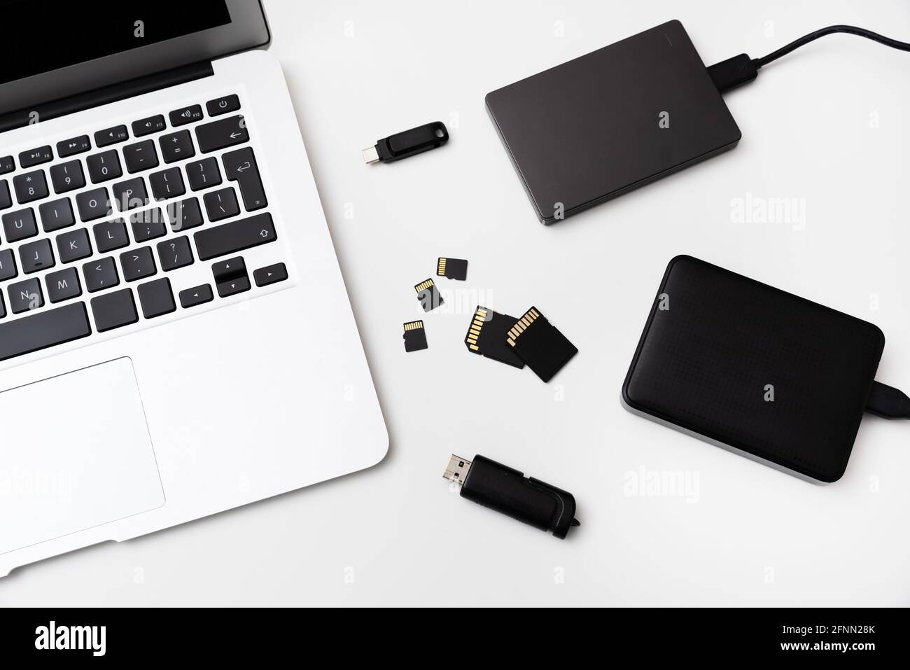 Plusieurs périphériques de stockage, poignée de commande, disque USB externe, cartes mémoire sur ordinateur portable Banque D'Images