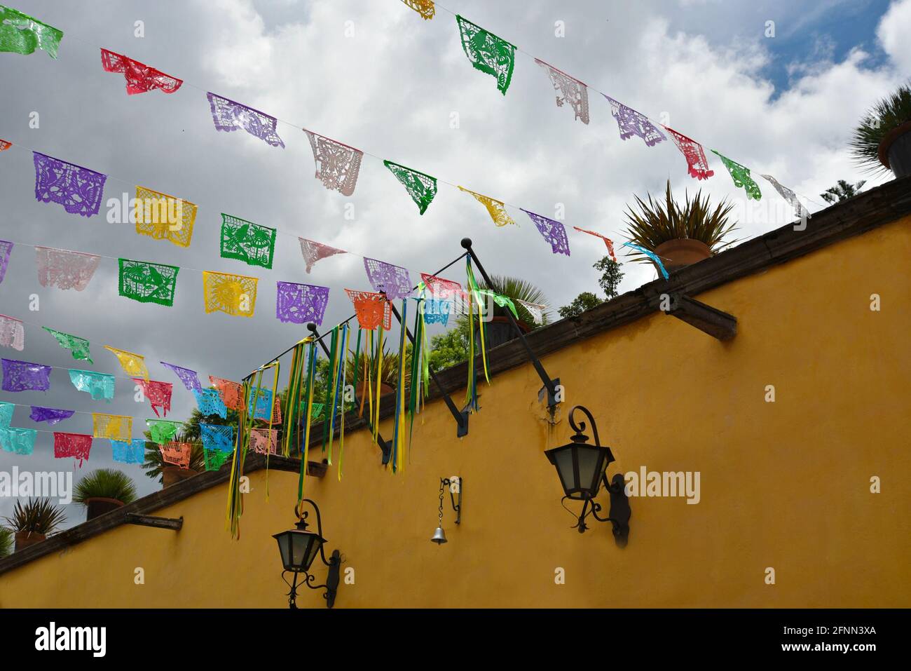 Façade ocre élégante typique de l'architecture de l'époque coloniale espagnole avec des banderoles en paper de fête colorées picado à San Miguel de Allende Mexique Banque D'Images