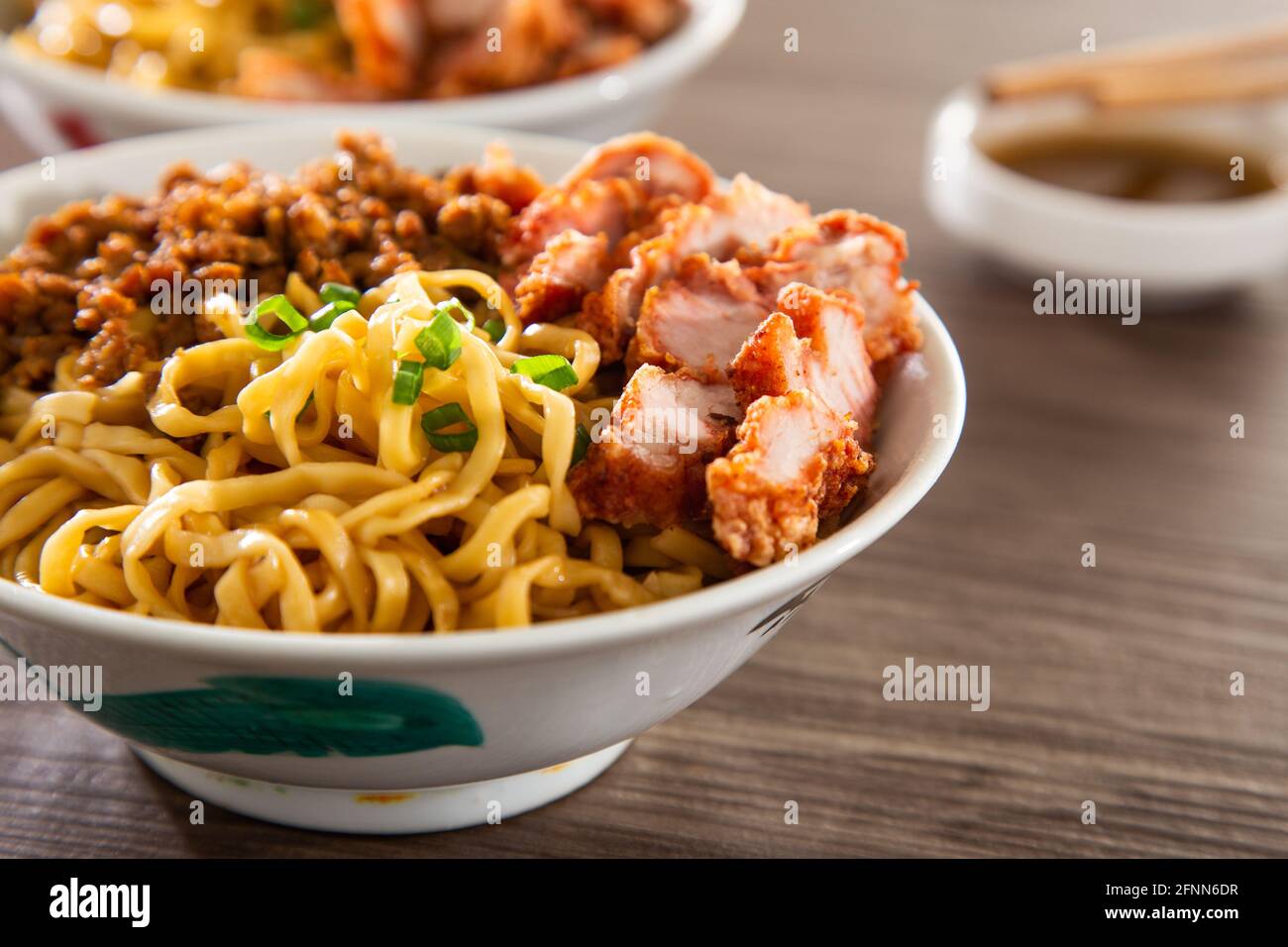 Un Kolo Mee est un plat malaisien de Sarawak de nouilles sèches, servies dans un savoureux mélange de porc et d'échalotes, nappé d'oignons frits parfumés. Banque D'Images