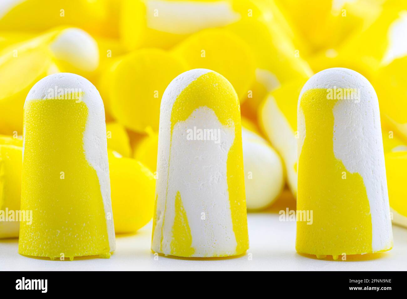 Prise de vue macro de trois bouchons d'oreilles jaunes et blancs pour la  protection contre le bruit Photo Stock - Alamy