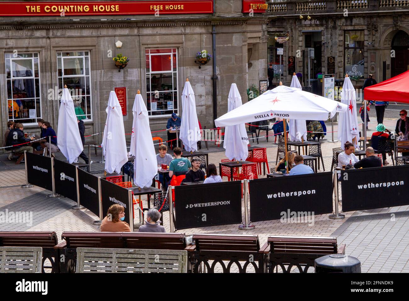 Dundee, Tayside, Écosse, Royaume-Uni. 18 mai 2021. Météo au Royaume-Uni : soleil de printemps chaud dans le nord-est de l'Écosse avec des températures atteignant 15°C. Les restrictions de verrouillage de Covid-19 sont désormais assouplies au niveau 2 à Dundee en voyant les gens profiter des nouvelles réglementations assouplies et en socialisant à l'intérieur et à l'extérieur des pubs locaux. Les restrictions de niveau 2 permettent aux pubs Dundee de rester ouverts pour affaires jusqu'à 22h30. Les clients peuvent profiter du temps pour boire et manger à la maison publique J.D Wetherspoon's Counting House. Crédit : Dundee Photographics/Alamy Live News Banque D'Images