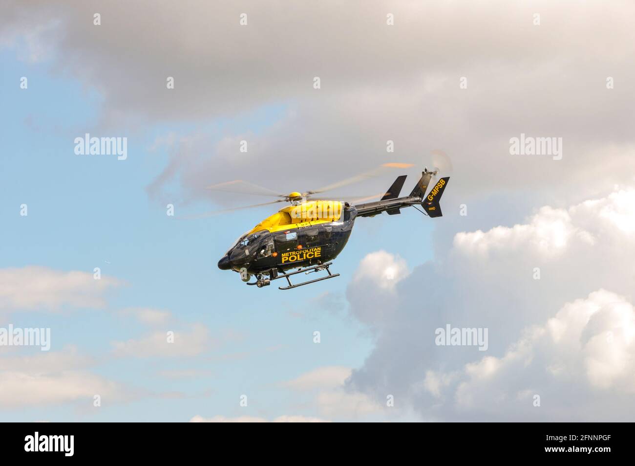 Hélicoptère de police métropolitaine Eurocopter EC145 G-MPSB à North Weald, Essex, Royaume-Uni. Voler dans un nuage brisé. Jour lumineux et ensoleillé. Banque D'Images