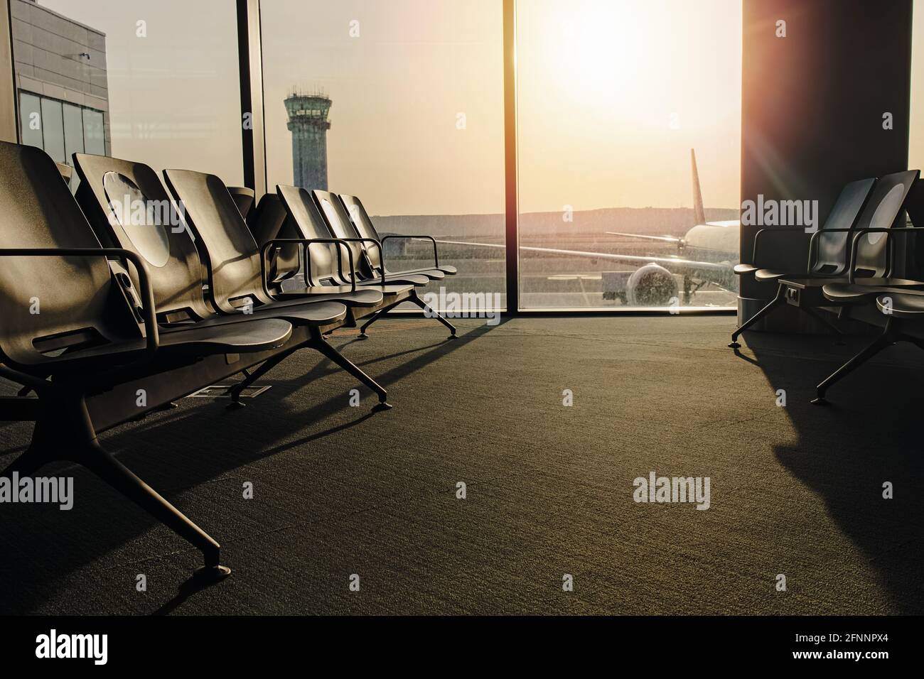 Chaises dans la salle d'attente à l'aéroport à la porte avec lumière du soleil Banque D'Images
