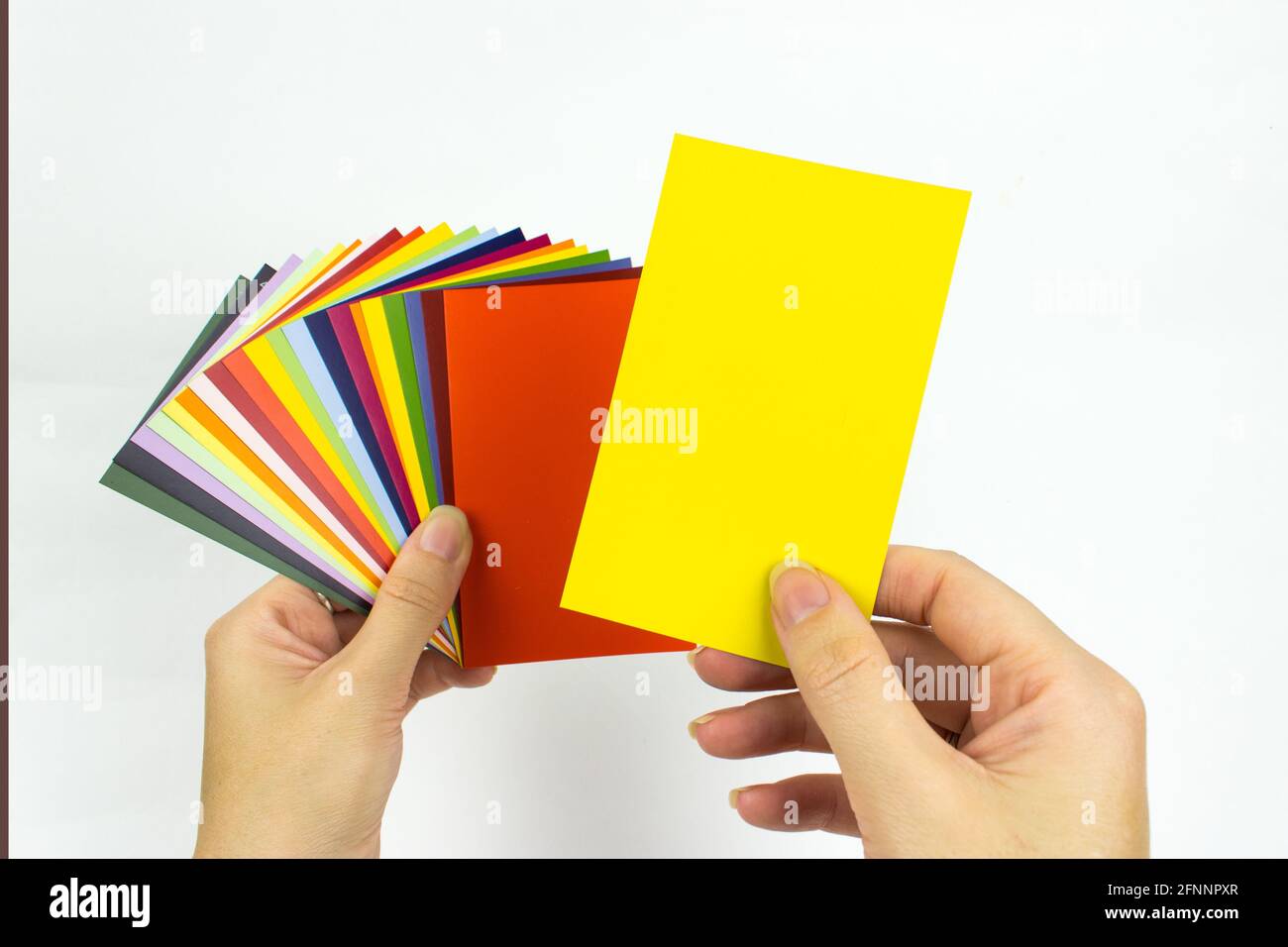 Échantillons de peinture de carte couleur en mains. Palette de peintures pour réparation dans les mains Banque D'Images