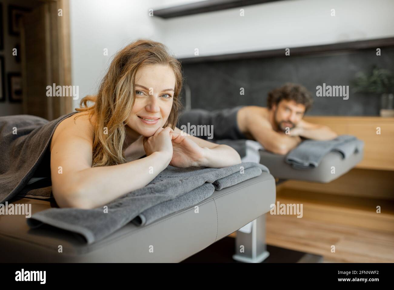 Beau couple allongé dans un salon de spa et attendant le masseur pour le massage profond du dos et la détente. Le bien-être et les loisirs pour les soins de santé ensemble. Concentrez-vous sur la femme souriante. Banque D'Images