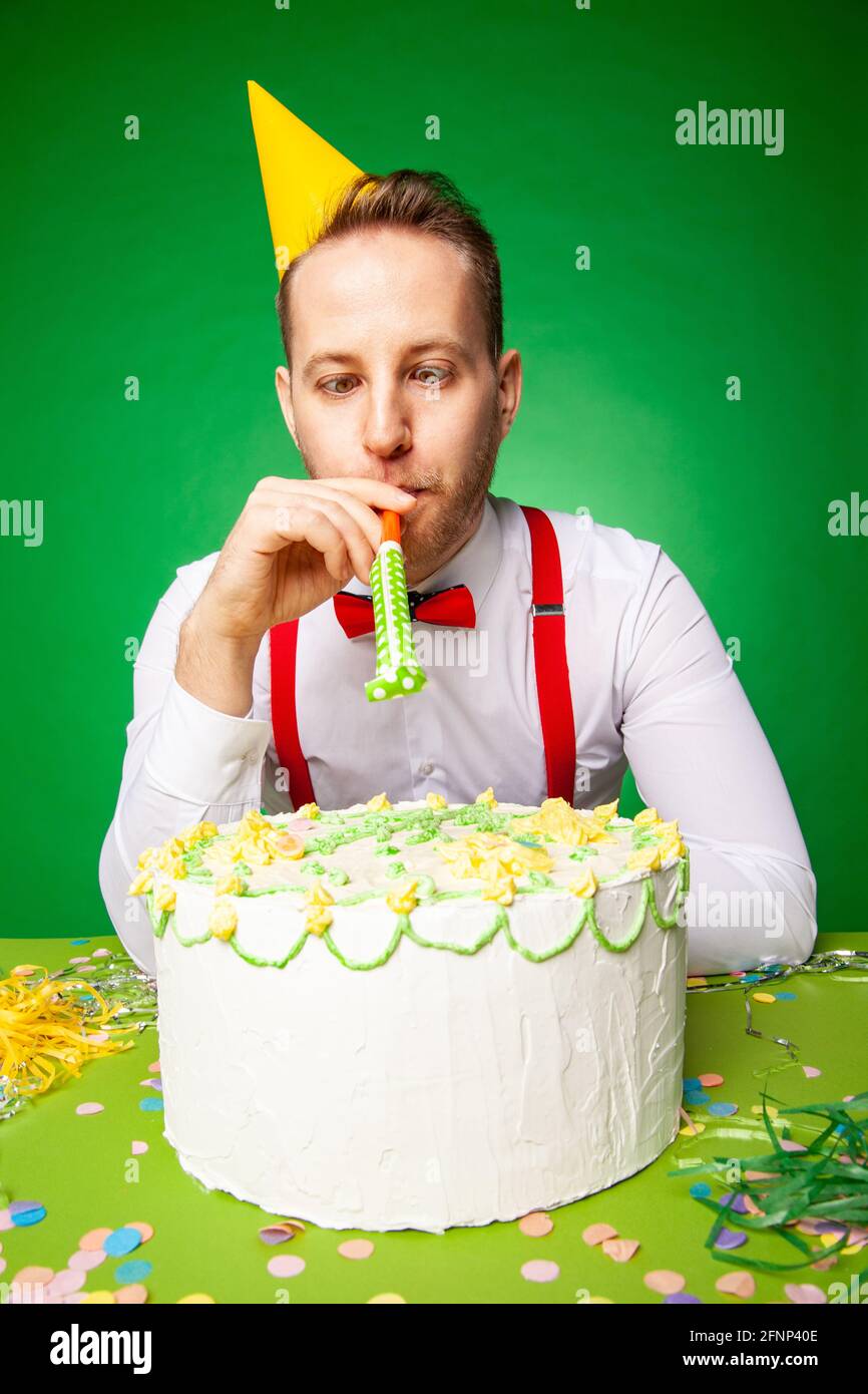 Homme En Fete Chapeau Assis A Table Avec Un Joyeux Anniversaire Gateau Et Souffleur De Bruit Sur Le Fond Vert En Studio Photo Stock Alamy Homme En Fete Chapeau Assis A Table Avec Un Joyeux Anniversaire Gateau Et Souffleur De Bruit Sur Le Fond Vert En Studio Photo Stock Alamy