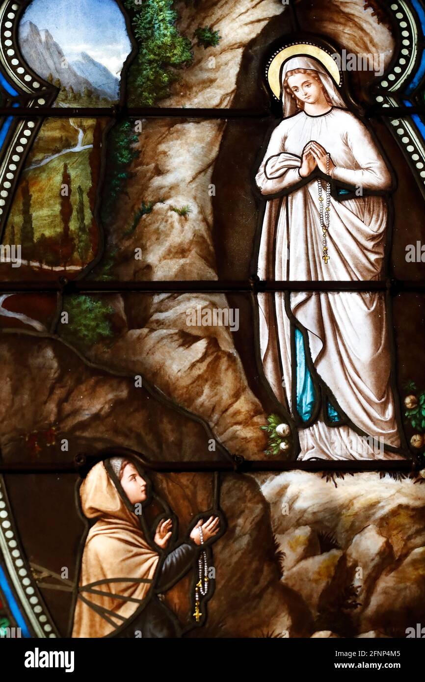 Basilique notre Dame de l’Assomption. Fenêtre en vitrail. Notre dame de Lourdes et Bernadette Soubirous. Bien. France. Banque D'Images