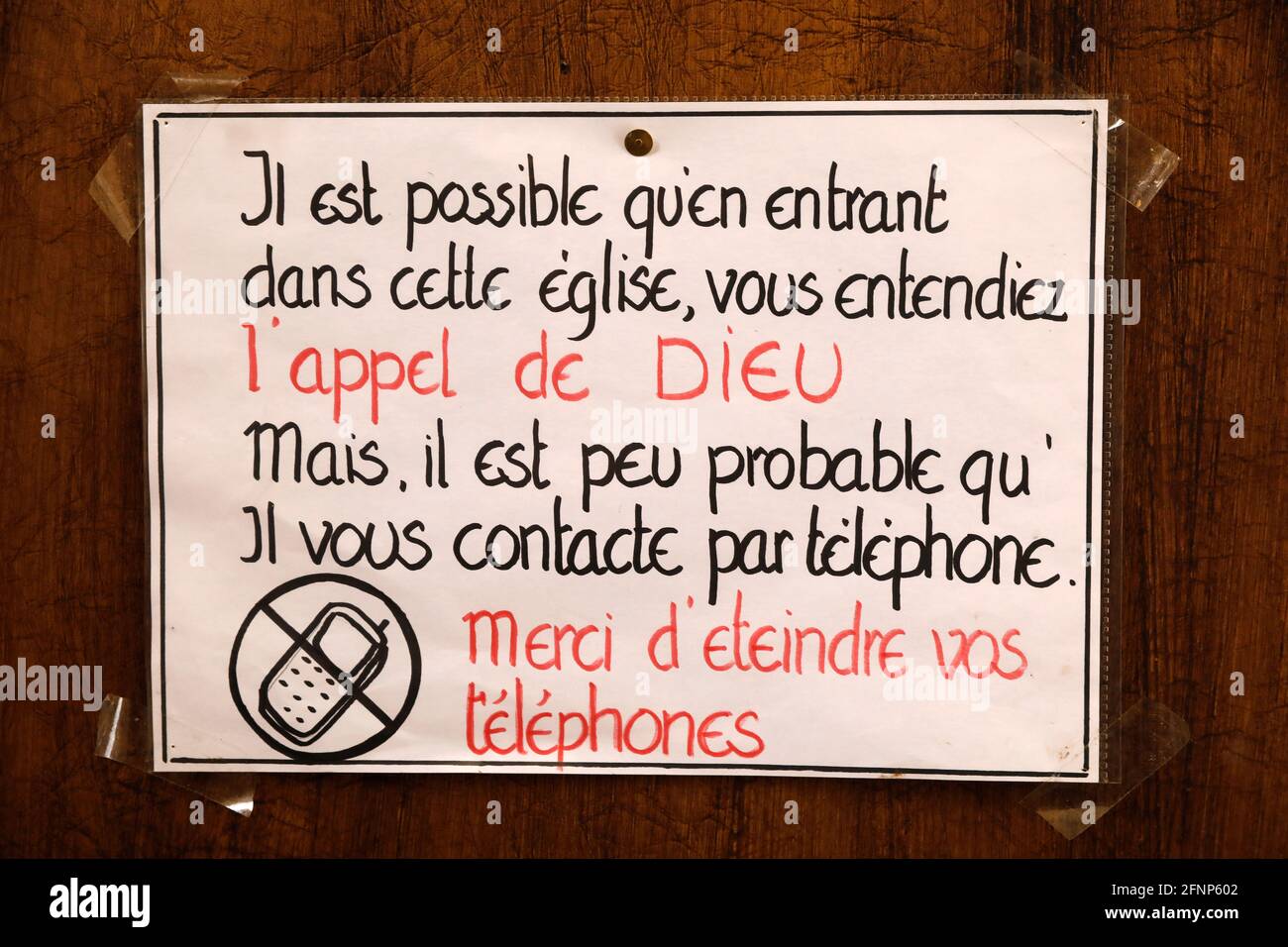 Signe humoristique à la porte d'une église de Paris, France : vous pouvez être appelé par Dieu, mais pas sur votre téléphone cellulaire. Veuillez l'éteindre Banque D'Images