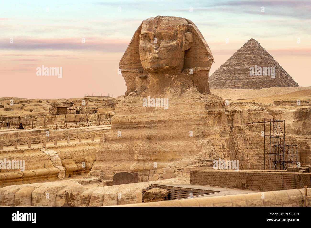 Vue générale sur les pyramides avec Sphinx. Le Sphinx dans le complexe de la pyramide de Gizeh au coucher du soleil. Vue incroyable sur la face du Sphinx et la grande pyramide Banque D'Images