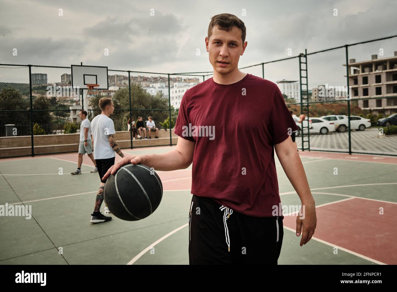 L'homme joue au basket-ball sur le terrain extérieur Banque D'Images