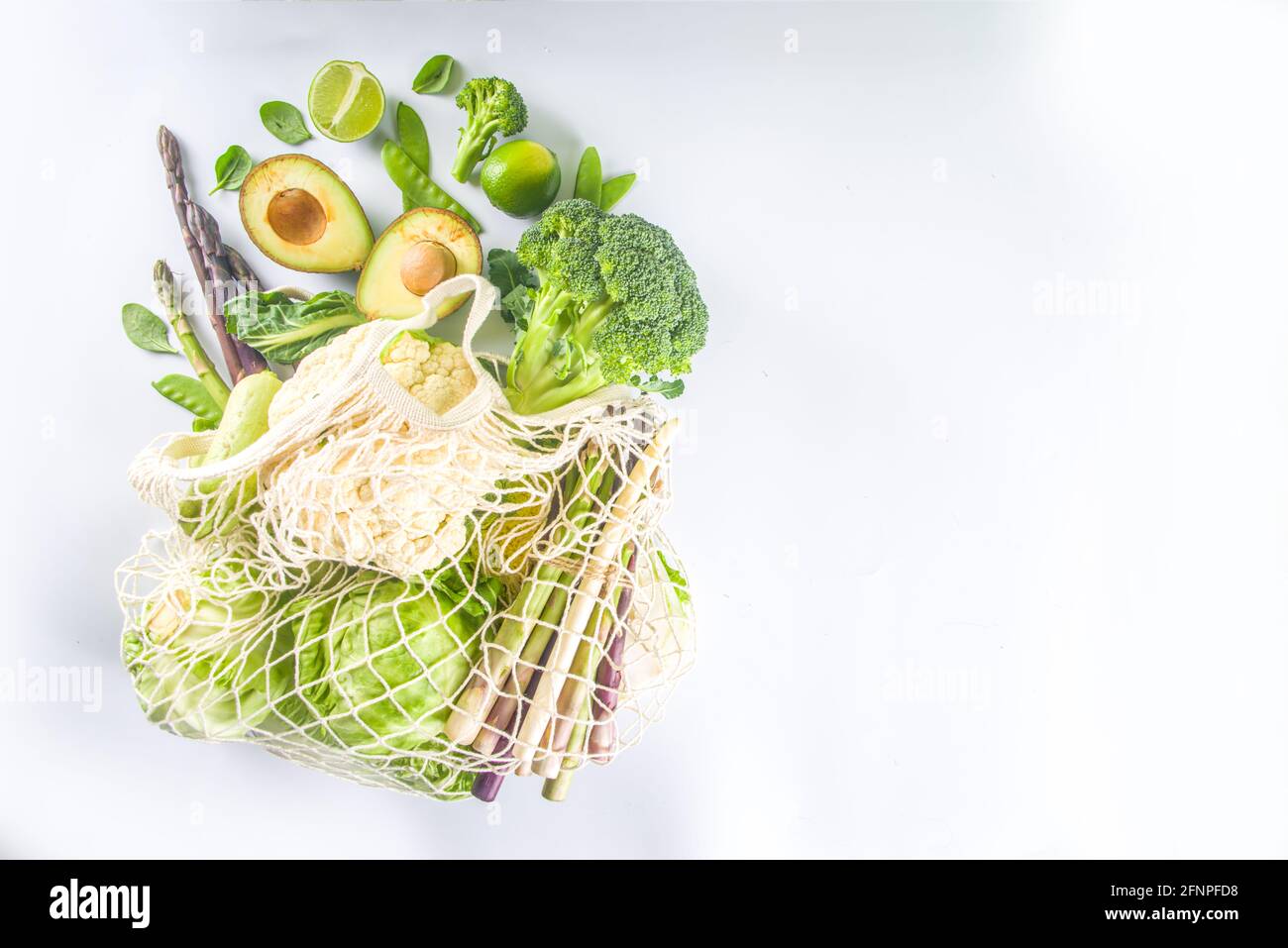 Green veggie shopping concept, sac réutilisable écologique avec divers légumes verts frais sur fond blanc vue du dessus Banque D'Images