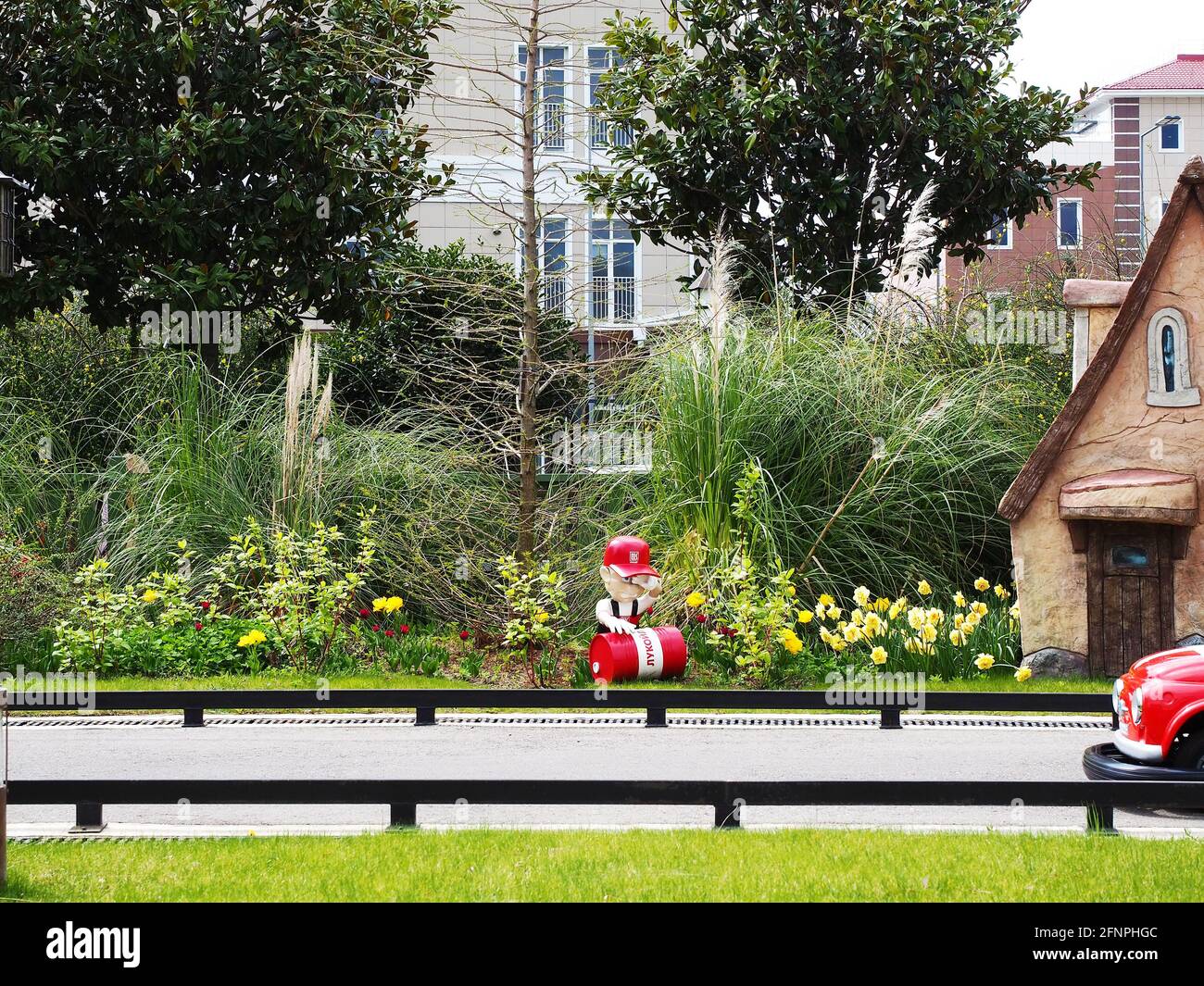 Russie, Sotchi 16.04.2021. Une figurine d'un homme au canon rouge avec l'inscription Lukoil se tient sur la pelouse le long d'une route miniature pour un K d'enfant Banque D'Images