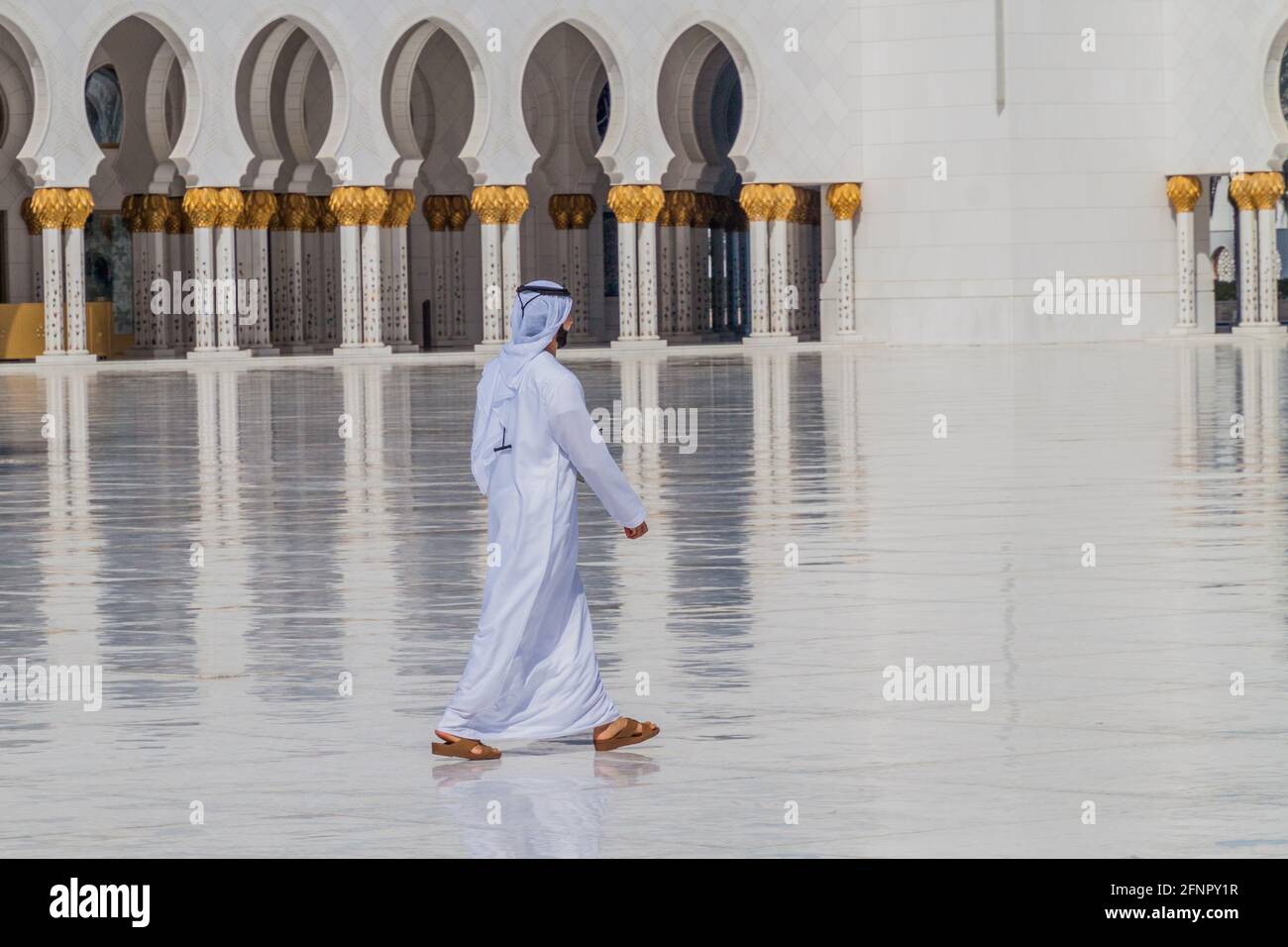 ABU DHABI, Émirats Arabes Unis - 9 MARS 2017 : des hommes locaux marchont dans la cour de la Grande Mosquée Sheikh Zayed à Abu Dhabi Banque D'Images
