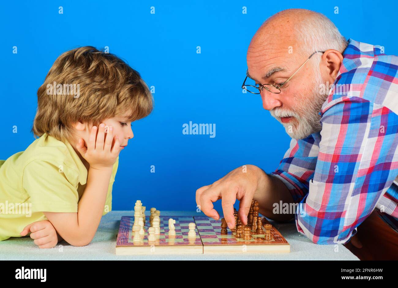 Petit-fils jouant aux échecs avec grand-père. Grand-père enseignant le petit-enfant jouer aux échecs. Relation familiale. Banque D'Images